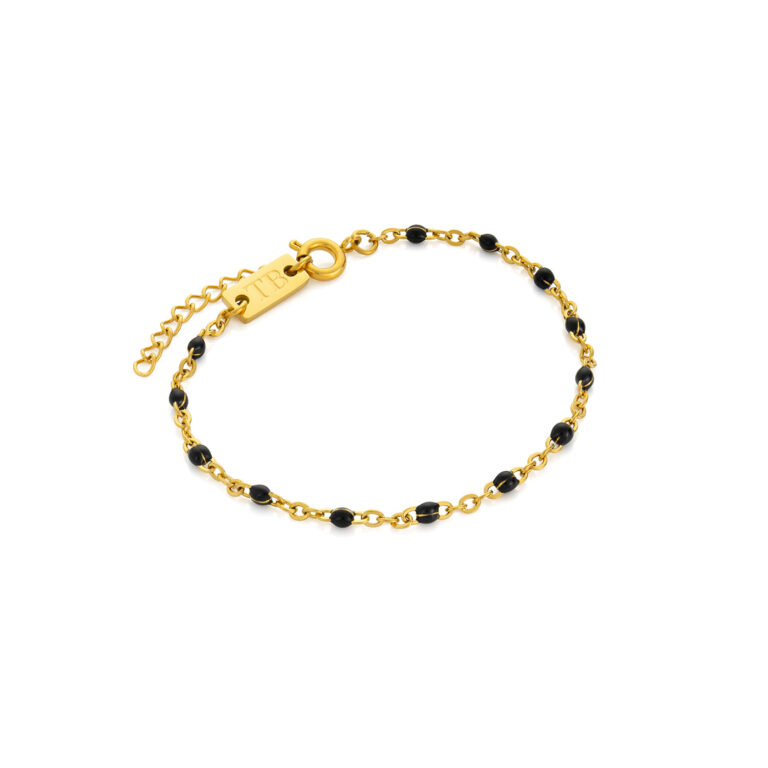 Pulsera fina de mujer dorada con piedras negras.